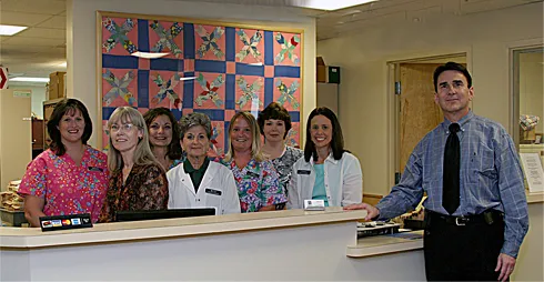 The team at the front desk of the first Ullman Eye Consultants office in 2005, with Dr. Saul Ullman at the right