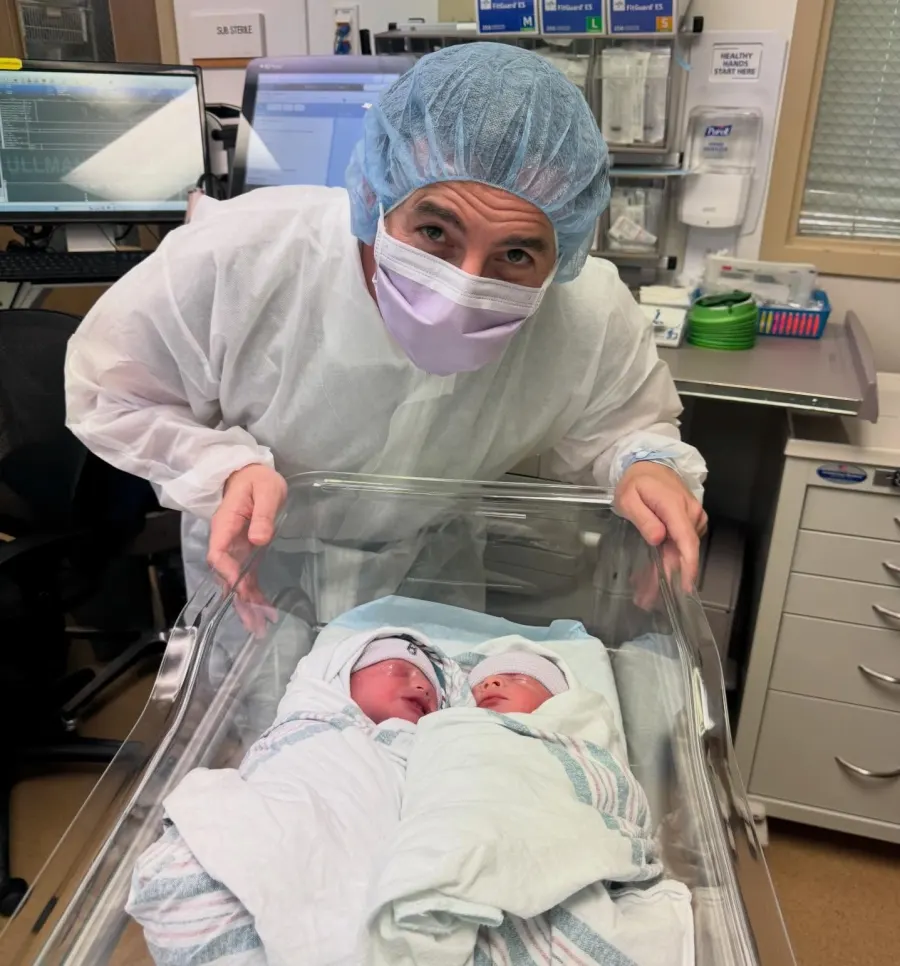 Dr. Michael Ullman in surgical scrubs with his newborn twins