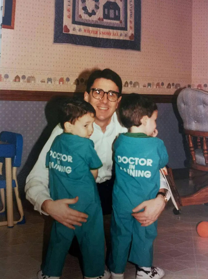 A young Dr. Michael Ullman and his twin brother in "Doctor in Training" scrubs